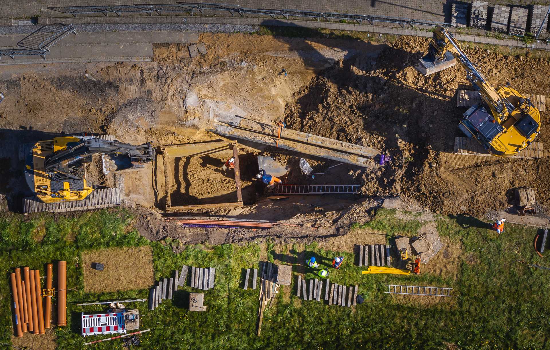 Drone photo of a construction site with excavators and workers performing excavation work.